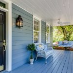 a porch with two chairs and a table on it